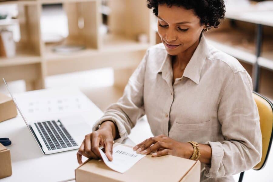 Woman confidently labeling and shipping e-commerce packages during peak season rush
