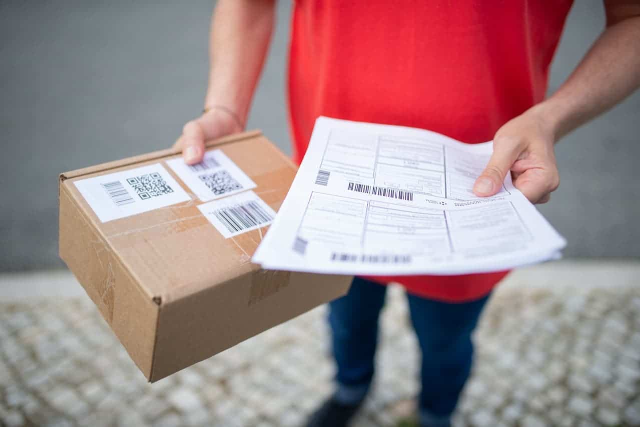 Mann trägt Paket mit Retoure und Dokumente mit RMA Nummer