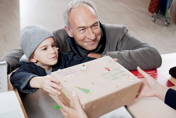 Großvater und Kind geben Paket für Weihnachten ab